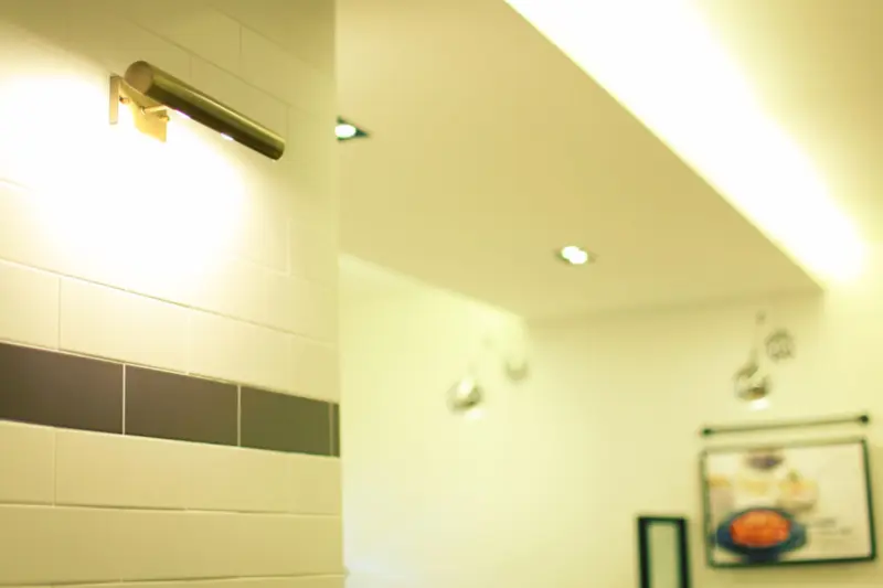 서브웨이 타일과 골드 조명의 모던 식당 디테일